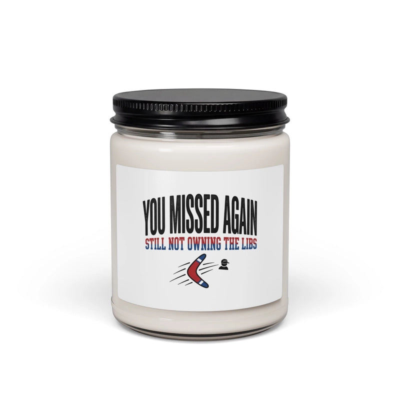 A soy candle in a glass jar with a label that reads You Missed Again Still Not Owning The Libs.