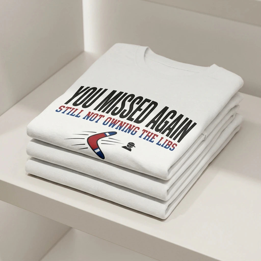A white crew neck t-shirt folded on a shelf with the text You Missed Again and a boomerang icon.