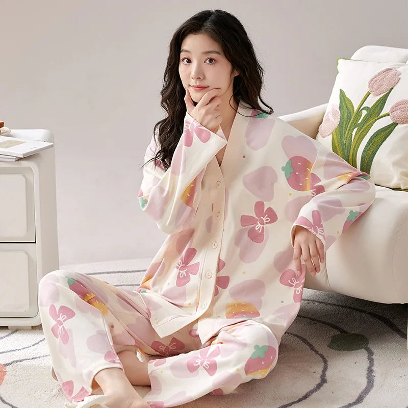 A woman wears a long-sleeved, V-neck pajama set featuring a pink and white strawberry print.