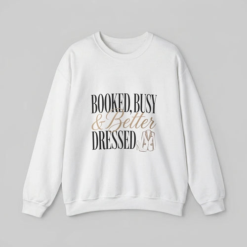 A white crewneck sweatshirt featuring the text Booked, Busy & Better Dressed with a blazer graphic.