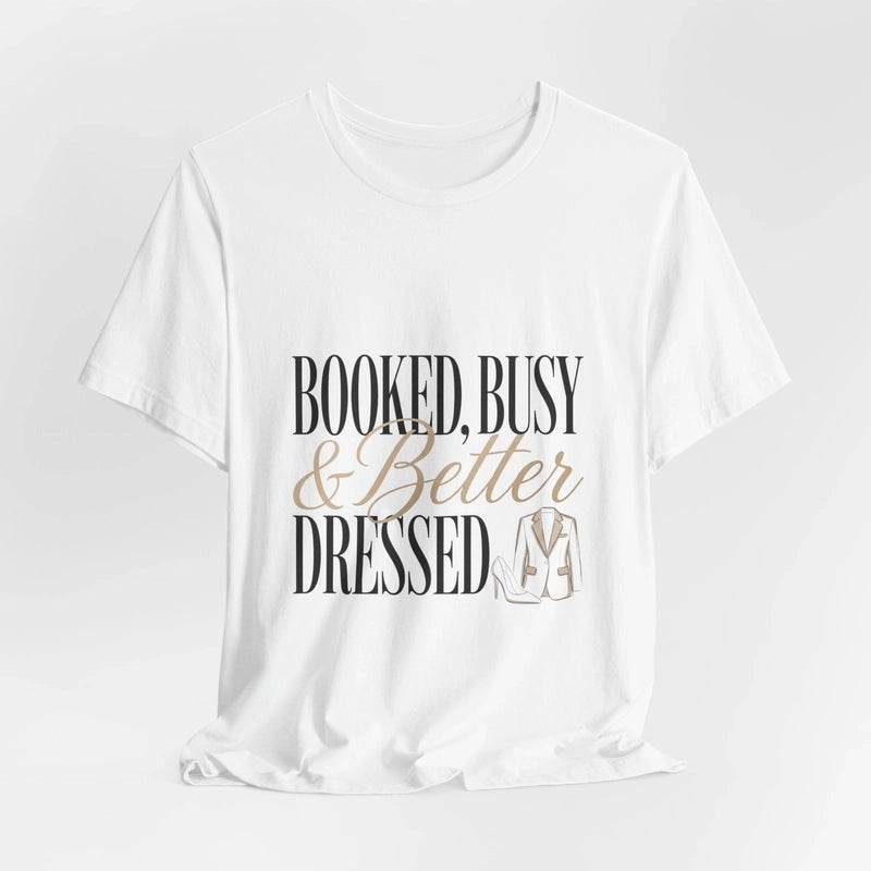 A white crew neck t-shirt featuring the text Booked, Busy and Better Dressed with a blazer graphic.