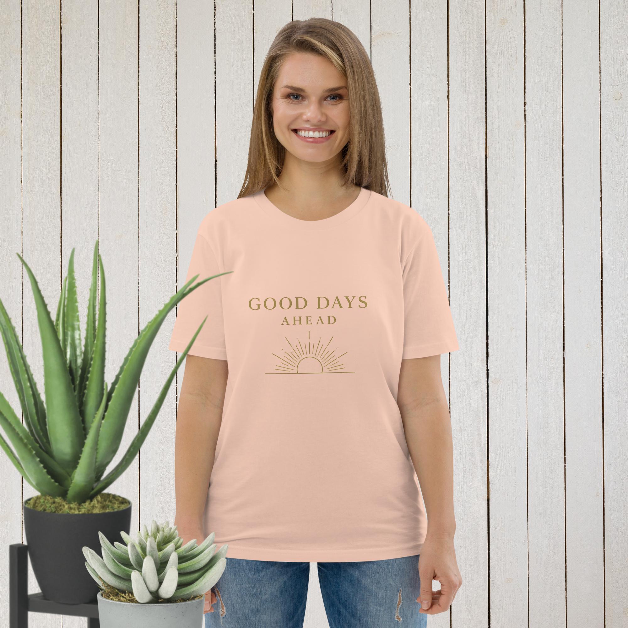 A woman wears a peach-colored t-shirt with the text Good Days Ahead and a sun graphic.
